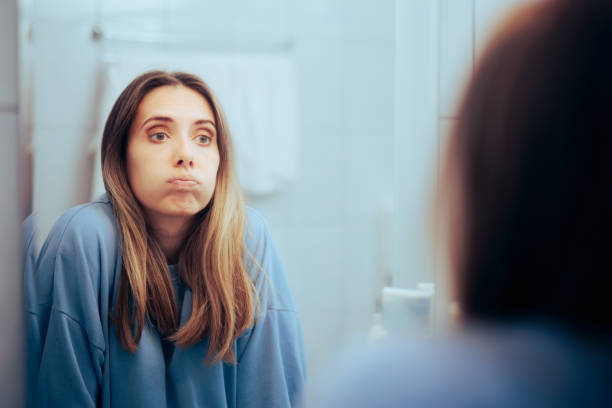 woman staring at mirror looking confused, representing gaslighting